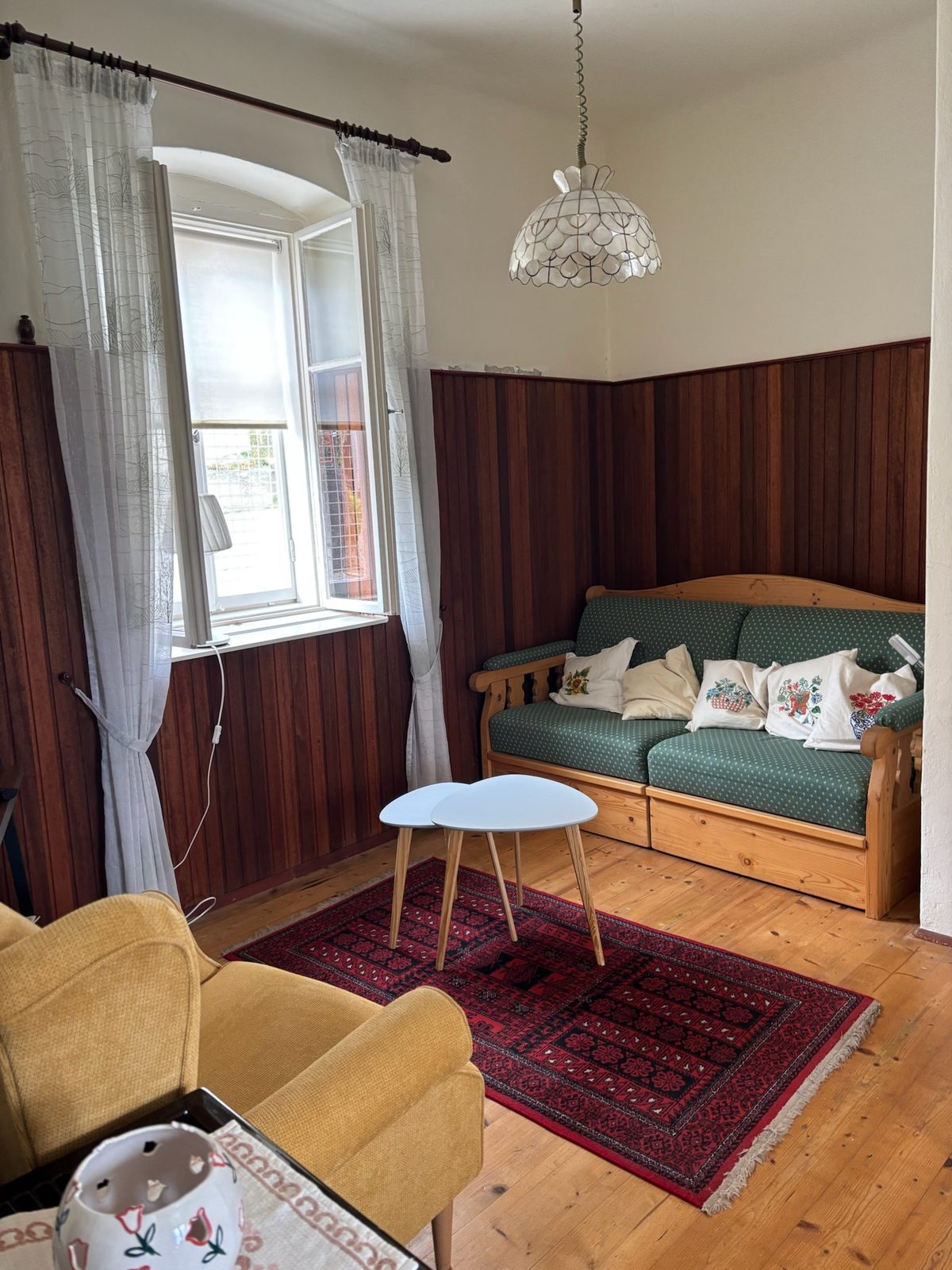 Gemütliches Wohnzimmer mit Holzvertäfelung und antiken Möbeln